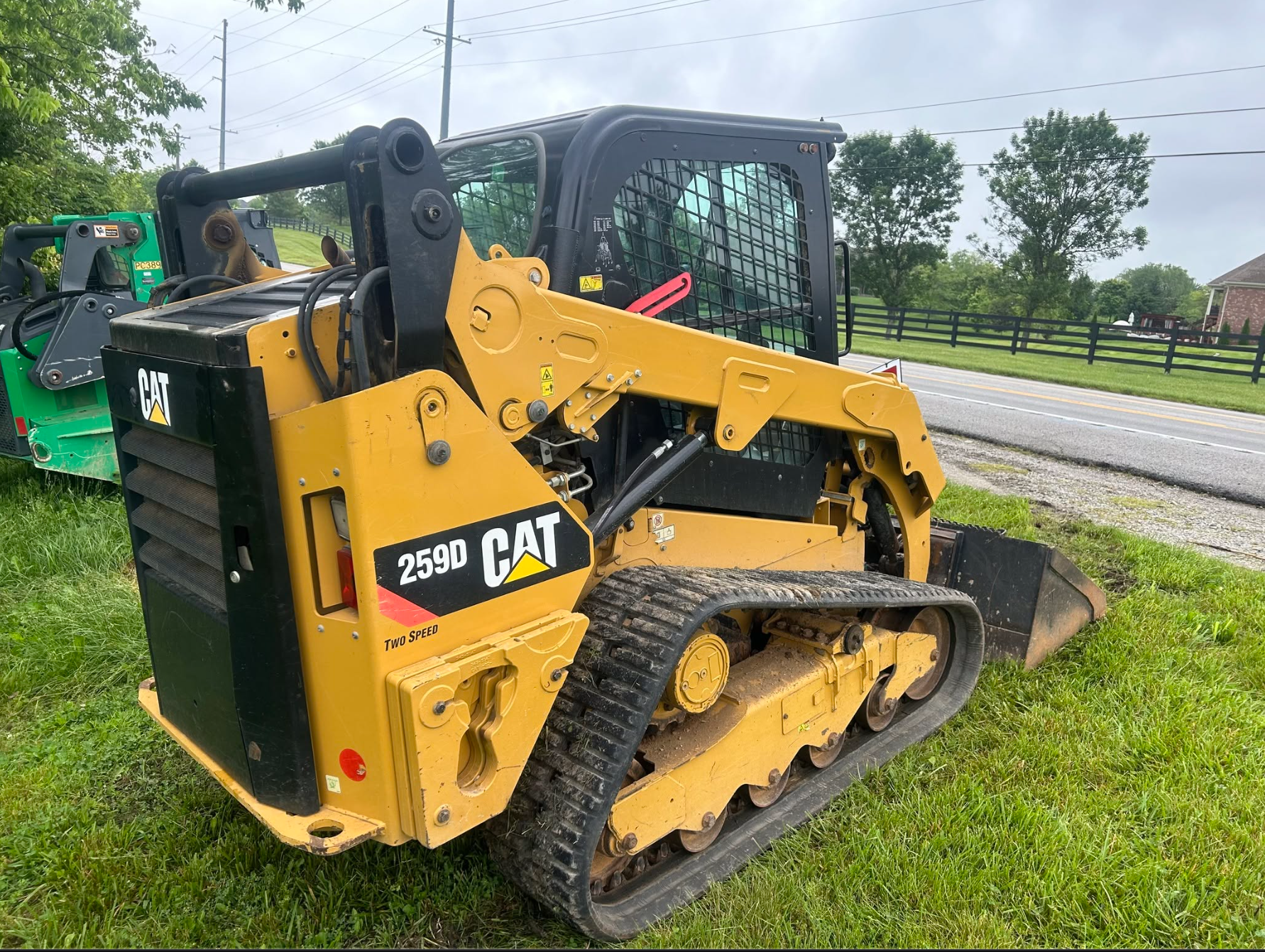 Yellow compact tracked loader in a field