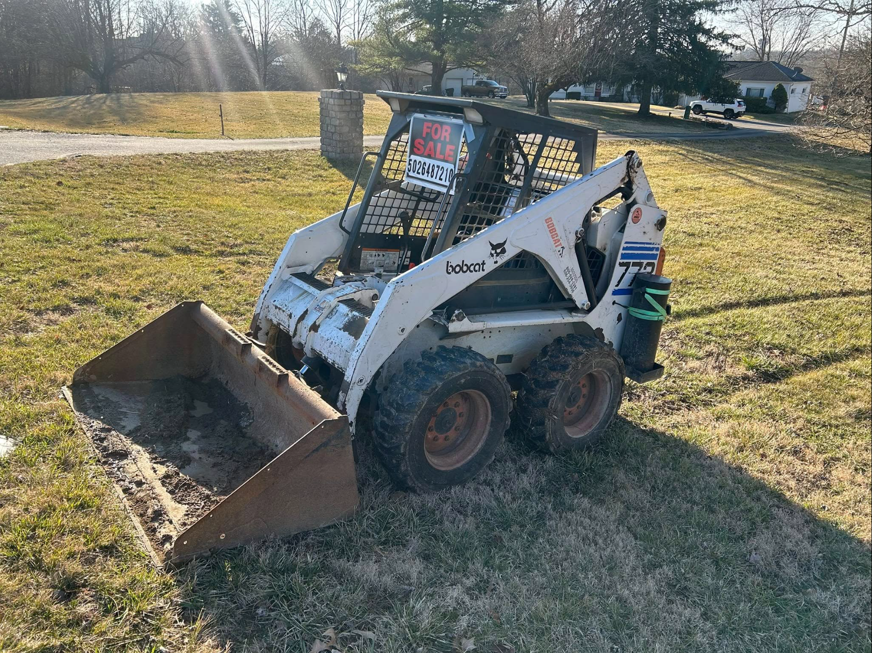 White compact skid steer with bucket