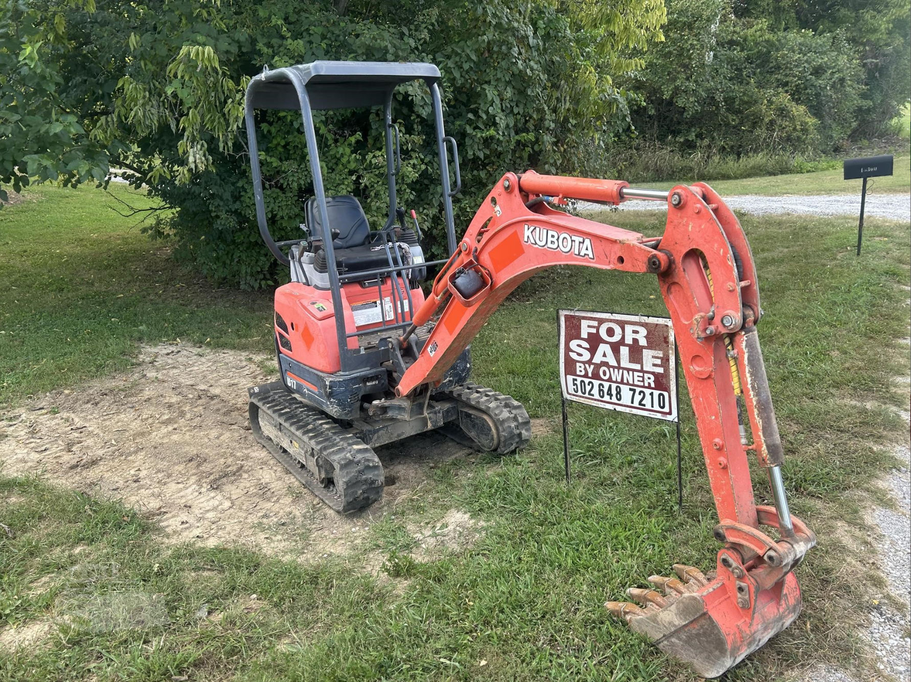 Red mini excavator with bucket